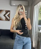 Top asimétrico negro con un solo tirante y detalle de strass plateados.