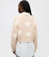Suéter de punto con diseño de corazones en contraste, cuello redondo y mangas largas con sisa desplazada.