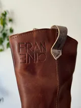 Bota de cuero marrón con estribo desmontable plateado.