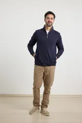 Cardigan de tejido de punto color verde militar, con cierre frontal de metal y cuello redondo. Presenta detalle de tejido plano en la cartera del cierre y en los bolsillos laterales.