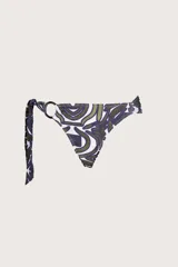 Bombacha de bikini con diseño asimétrico, presenta un detalle de argolla circular en uno de los laterales y tiras para anudar. Posee un estampado orgánico en tonos verde oscuro y azul sobre fondo blanco.