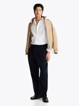 Camisa blanca de popelín de puro algodón con Flex Technology, cuello inglés, puños redondeados con botones y logo de Tommy Hilfiger bordado en el pecho.