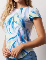 Remera color beige con estampado de hojas blancas, cuello redondo y mangas cortas.