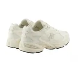 Championes New Balance ML725 color crema con detalles en gris, confeccionados en malla y material sintético.