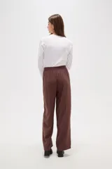Pantalon de viscosa color verde militar, de corte ancho y tiro medio, con cintura elástica y cordón ajustable.