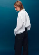 Pantalón de jean estilo wide leg de tiro medio, con diseño de cinco bolsillos, trabillas para cinturón y cierre frontal con botones.