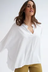 Blusa blanca de manga corta, con escote en V y cuello mao.