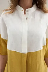 Camisa larga de lino con diseño bicolor en tonos beige y marrón, cuello mao y mangas cortas.