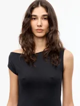 Vestido largo negro de manga corta con escote asimétrico y ruedo irregular. Cuenta con recortes delanteros y traseros.