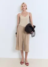 Top de punto fino con acabado metalizado, escote en pico y tirantes finos. Presenta un diseño recto y sencillo, ideal para diversas ocasiones.