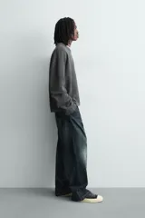 Sudadera de corte relajado confeccionada en tejido de algodón con textura acanalada. Presenta cuello redondo, manga larga y un diseño con efecto lavado. Incluye un texto estampado en contraste en la parte frontal.
