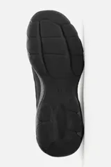 Zapatilla deportiva tipo running de color negro, perteneciente a la colección especial Origins. Presenta una parte superior confeccionada en una combinación de cuero con acabado de gamuza y tejido transpirable. Cuenta con una suela de volumen con diseño irregular y cierre mediante cordones.