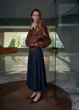 Falda midi plisada de color gris oscuro, con diseño acampanado y talle alto.