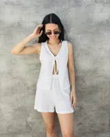 Chaleco tejido color beige con lurex, escote en V y lazos para atar en el frente.