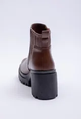 Bota de caña baja color negro, con elástico lateral, punta redonda y taco plataforma.