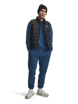 Pantalón de jogging Under Armour, confeccionado en tejido polar de mezcla de algodón con interior cepillado. Presenta cintura elástica con cordón exterior, bolsillos laterales abiertos, un bolsillo trasero con cierre a presión y puños elásticos en los tobillos. Incluye logotipo bordado en la pierna.