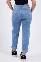 Pantalón de jean celeste con roturas en las rodillas y ruedo doblado.