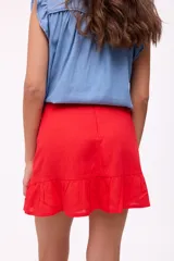 Falda corta de lino color bordó, con cierre trasero y un volante fruncido en el ruedo.