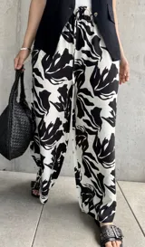 Pantalón palazzo de tiro alto con estampado floral abstracto en blanco y negro, con cintura elastizada y cordón ajustable.