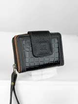 Billetera compacta de cuero negro con diseño combinado de textura granulada y efecto crocco brillante. Cuenta con cierre perimetral, solapa frontal con broche y logo grabado, e incluye una correa de muñeca extraíble.