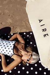 Lona playera rectangular de algodón color negro con lunares blancos.