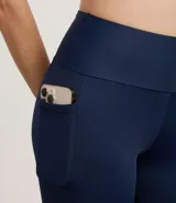 Calza legging deportiva azul marino de microfibra, con cintura ancha, bolsillos laterales y recorte en el bajo.