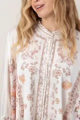 Camisa de seda modelo pañuelo, de color amarillo con estampado estilo mandala y flores, cuello redondo y cierre frontal con botones.