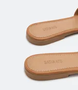 Sandalia plana marca Satinato, color blanco, con diseño de tiras en forma de H y puntera cuadrada.