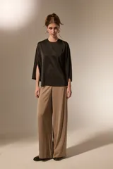 Blusa de satén color negro, con cuello redondo a la base, mangas 3/4 con abertura lateral y diseño holgado.