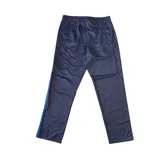 Conjunto deportivo Umbro de campera y pantalón en color gris. La campera es de cuello alto, con cierre frontal completo y bolsillos laterales con cierre. El pantalón cuenta con cintura elástica y bolsillos laterales. Ambos presentan detalles de franjas negras en los costados y el logo de la marca bordado.