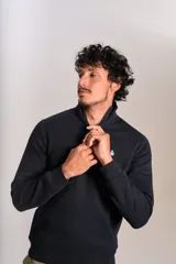 Buzo de cuello alto con cierre frontal parcial, manga larga y puños acanalados. Presenta un diseño liso en color negro con el logo de la marca bordado en el pecho.