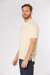 Remera polo lisa color amarillo pastel, confeccionada en piqué Oxford, con cuello en rib y botones personalizados.