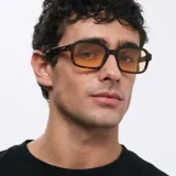 Lentes de sol cuadrados con ángulos redondeados, montura carey y lentes amarillas polarizadas.