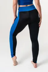 Calza deportiva de tiro alto con cintura elástica reforzada. Presenta un diseño bicolor que combina paneles laterales y faja con estampado animal print en tonos coral y turquesa sobre una base negra.