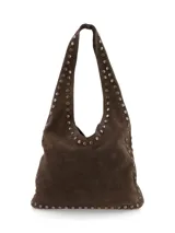 Cartera tipo hobo de gamuza marrón, decorada con tachas metálicas en los bordes y en las asas de hombro.