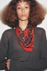 Pañuelo cuadrado de seda y viscosa con estampado paisley en tonos oscuros, beige y detalles en rosado, con borde decorativo.