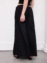 Falda larga marrón, de corte evasé con detalles de costuras horizontales y diseño fluido.