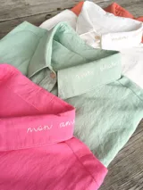 Camisa de manga larga color verde menta con cuello camisero, bordado con la frase "mon amour" en la solapa del cuello, cierre frontal con botones y bolsillo ojal en el pecho. Marca Bartola.