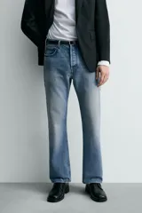 Jeans de mezclilla rígida de algodón, color azul claro con efecto lavado y ligero desgaste. De tiro medio, corte recto desde la cadera hasta la rodilla y ligeramente acampanado en el bajo (bootcut). Cierre frontal con botonadura y cinco bolsillos.