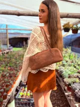 Cartera baguette de cuero color marrón con forro interno de tela.