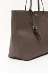 Cartera tipo tote de diseño minimalista y estructura flexible, confeccionada en material sintético con acabado mate. Cuenta con asas largas para llevar al hombro y un compartimento principal amplio.