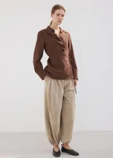 Camisa cruzada de color marrón, con diseño recto, cuello camisero, manga larga y cierre de lazo en la cintura con botones.