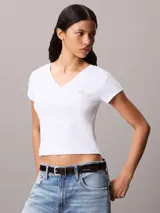 Remera de corte slim confeccionada en punto de algodón elástico con textura fina de canalé. Presenta cuello en V, manga corta y una insignia con el logo de Calvin Klein en el pecho.