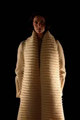 Tapado largo color crudo, confeccionado en lana merino afieltrada. Presenta cuello alto y guarda tejida en el cuello y ruedo. Tiene un estampado de una luna en la espalda.