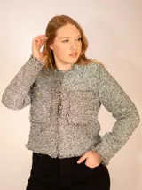 Chaqueta corta gris de tweed con detalles de flecos y botones dorados.