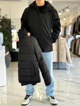 Campera 2 en 1 impermeable de color negro, con diseño con capucha y cierre frontal completo.