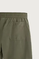 Short de baño largo en color beige, confeccionado en tejido técnico con tacto aterciopelado. Cuenta con cintura elástica ajustable con cordón, bolsillos laterales y detalle de bolsillo trasero, además de forro interior.