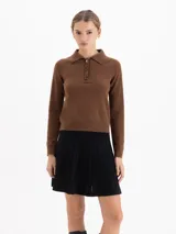 Sweater de punto color marrón, con cuello polo y cierre frontal de tres botones, de manga larga y corte recto.