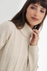 Vestido midi de tejido de punto color crema, con cuello alto, mangas largas y corte recto con aberturas laterales.