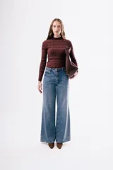 Top de manga larga de tejido de punto con cuello redondo, estampado geométrico en tonos rojos y rosados.